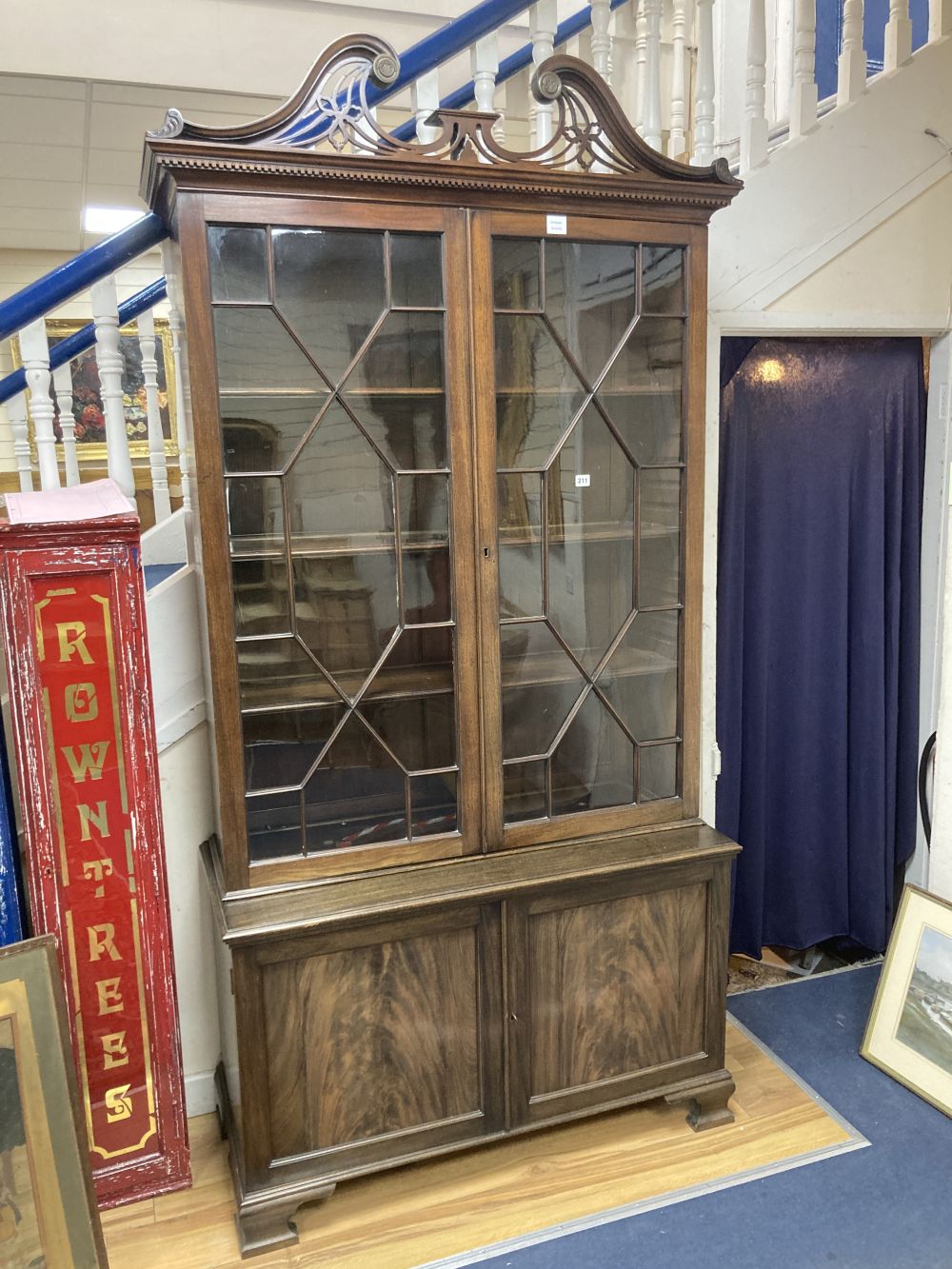 A George III style mahogany two door glass china display cabinet, with two panelled doors beneath, width 110cm depth 47cm height 220cm